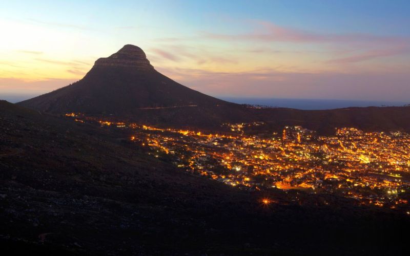 A stunning view of Cape Town at sunset with Lion’s Head in the background, showcasing why summer is the best month to visit Cape Town for breathtaking cityscapes.