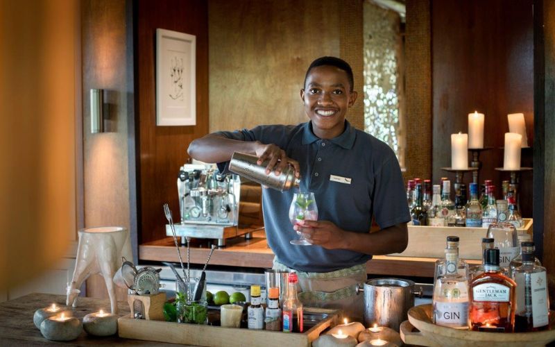 Employing from the local community like this barman is a way a lodge establishes sustainability.