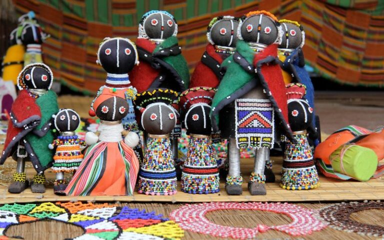 Handcrafted Ndebele dolls and colourful beaded artwork on display at a South African market.