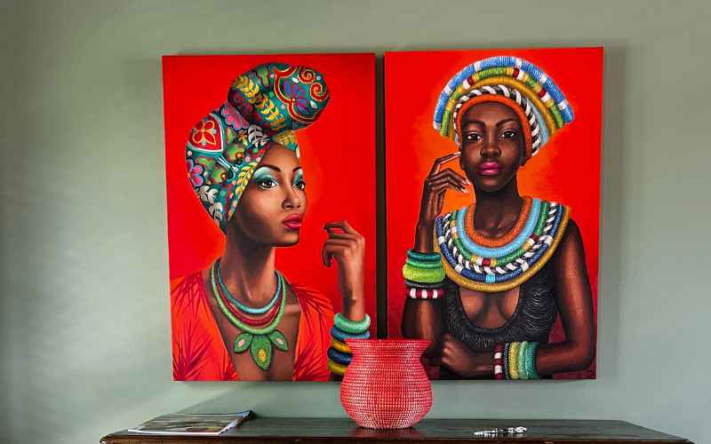 Vibrant African artwork featuring two elegantly dressed women in traditional attire, adorned with colorful jewelry and headwraps, set against a bold red background. Inspired by the rich culture and luxury experiences found at the most expensive safari lodge, Royal Malewane