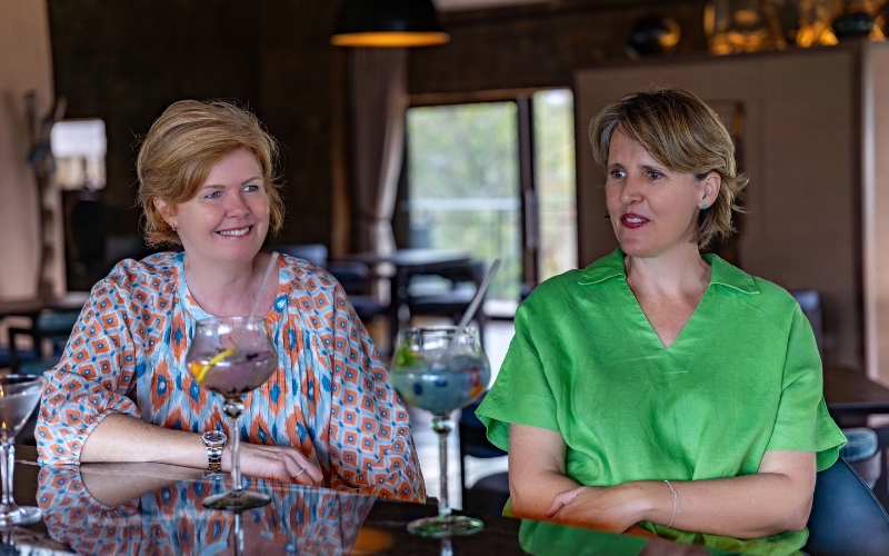 Sian Loehrer and Vikki Jackson, founders of Marula Hill Travel, enjoying handcrafted gin cocktails inside the lounge at Babohi Safari Lodge in Qwabi Private Game Reserve.